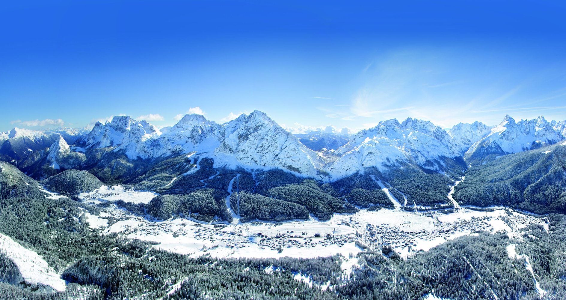 La valle di Sappada innevata vista dall'alto, circondata dalle Dolomiti